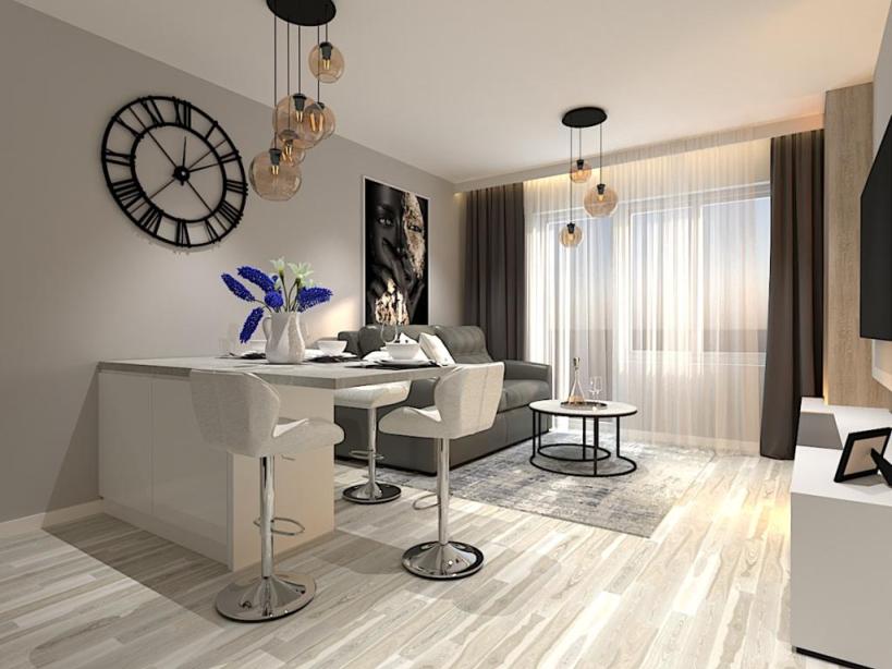 Salon z aneksem kuchennym widok na wyspę oraz salon z sofą