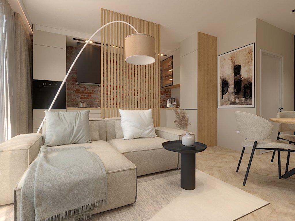 Projekt salonu z aneksem kuchennym Warszawa na wizualizacji widzimy kuchnię i salon w salonie znajduje się mały narożnik, stolik kawowy czarny, dywan i poduszki w kolorze biały i szarym, za sofą są lamele drewniane oddzielające część kuchenną, na zdjęciu widzimy kuchnię w kolorze biały z dodatkiem drewna