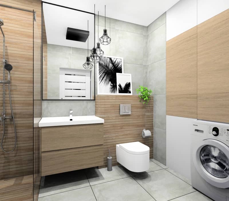 Łazienka w bloku, mieszkanie 50 m2, widok na szafke pod umywalkę drewnianą, zabudowę wc drewnianą, szare płytki na ścianie, lustro prostokątne w czarnej ramie, plakaty nad wc, kwiaty, przytulne wnętrze